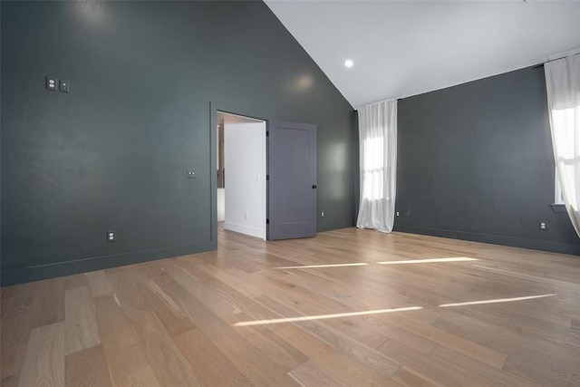 empty room featuring light hardwood / wood-style flooring and high vaulted ceiling