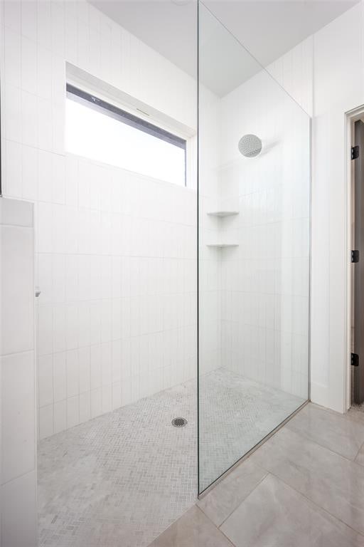 bathroom with tile patterned floors and tiled shower