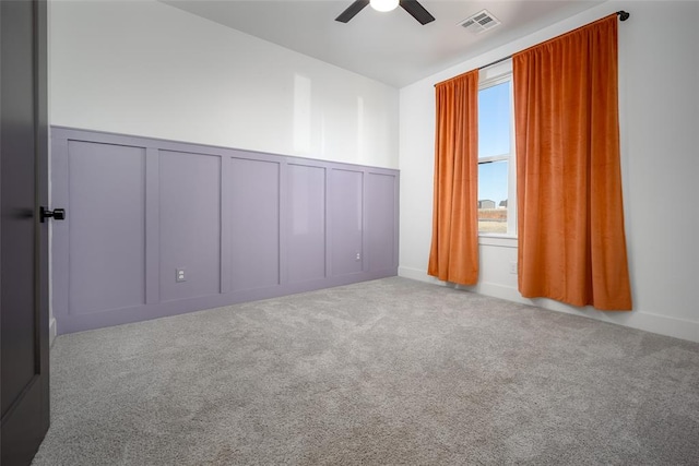 carpeted spare room featuring ceiling fan