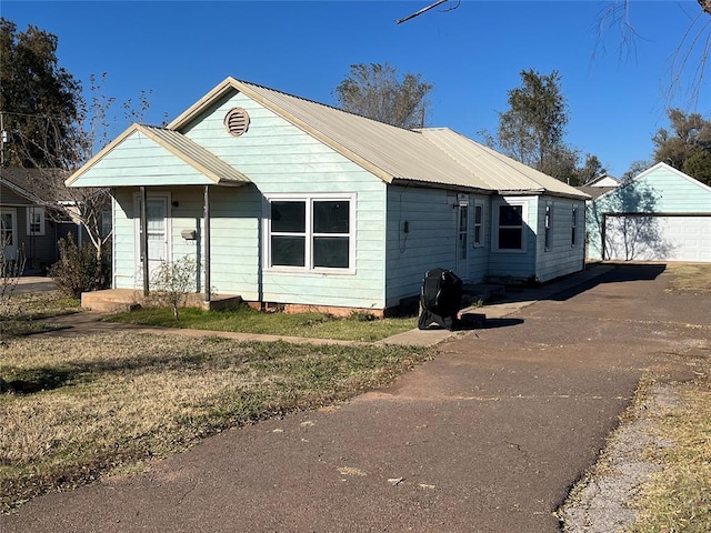 bungalow with a garage and an outbuilding