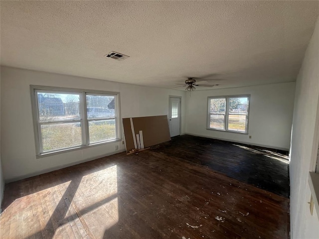 unfurnished room with ceiling fan, dark wood-type flooring, and a textured ceiling