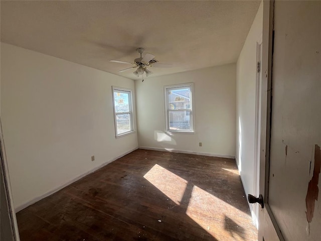 empty room with ceiling fan and dark wood-type flooring