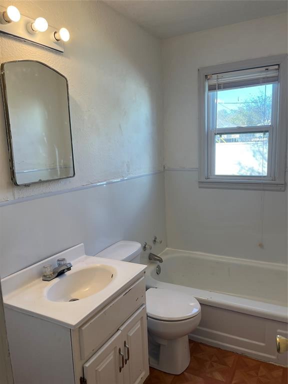 bathroom featuring a bathing tub, vanity, and toilet