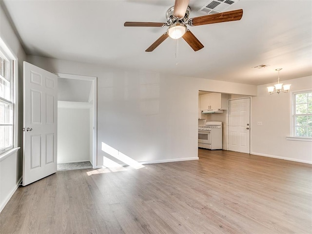 unfurnished living room featuring ceiling fan with notable chandelier and light wood-type flooring