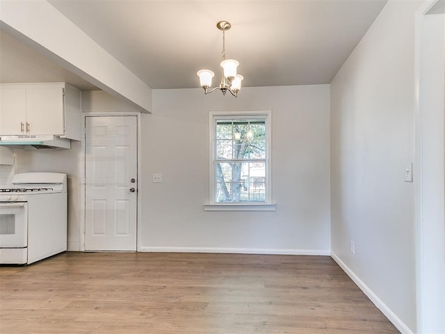 kitchen with white cabinets, light wood-type flooring, white range, and a chandelier