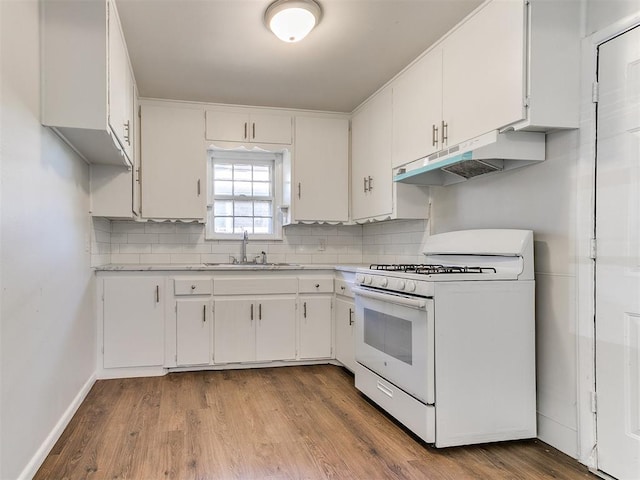 kitchen featuring decorative backsplash, white gas range, sink, white cabinets, and light hardwood / wood-style floors