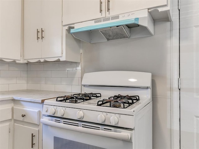 kitchen featuring white cabinets, decorative backsplash, and white gas range oven