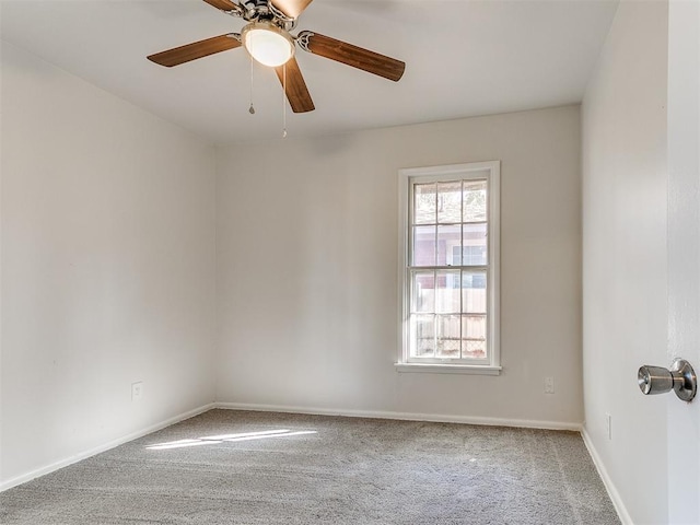 carpeted spare room featuring ceiling fan