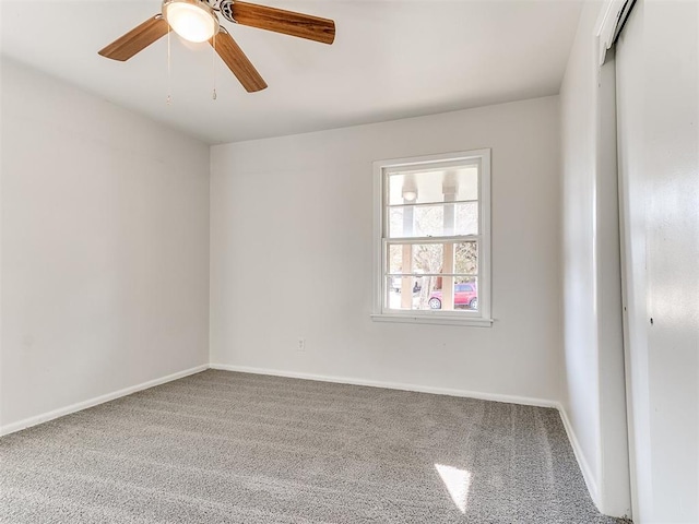 carpeted spare room with ceiling fan