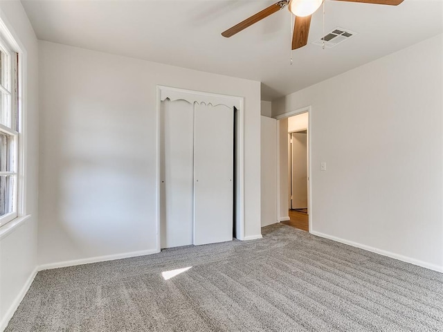 unfurnished bedroom with ceiling fan, a closet, and carpet