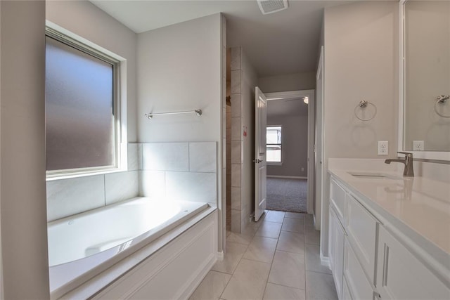 bathroom with tile patterned floors, a bathtub, and vanity