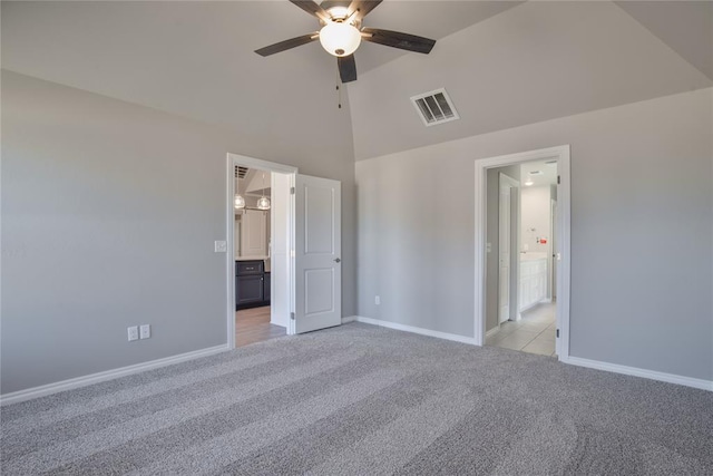 unfurnished bedroom with ensuite bathroom, ceiling fan, light colored carpet, and high vaulted ceiling