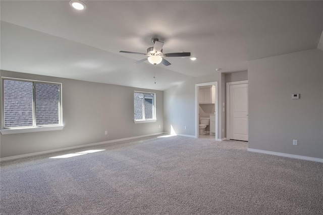 unfurnished bedroom with ceiling fan, light carpet, and ensuite bath