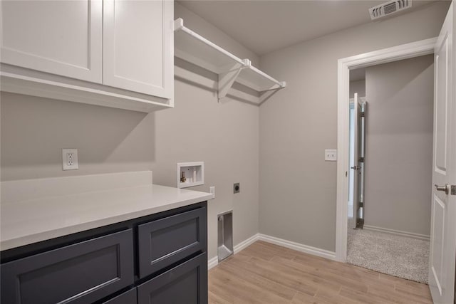 laundry room with electric dryer hookup, light hardwood / wood-style flooring, cabinets, and washer hookup