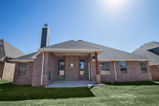 rear view of property featuring a lawn and a patio