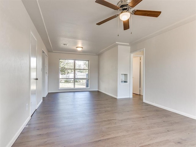 spare room featuring light hardwood / wood-style flooring, ceiling fan, and crown molding