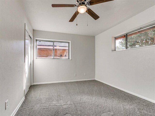 carpeted empty room with ceiling fan and a healthy amount of sunlight