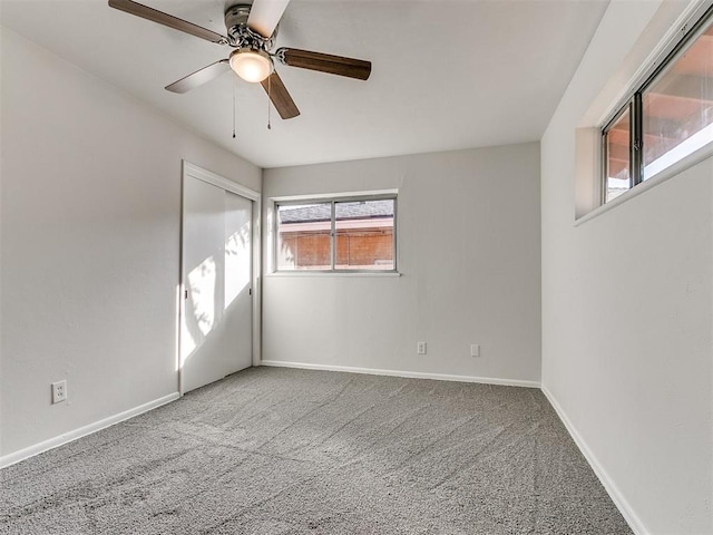 carpeted spare room with ceiling fan