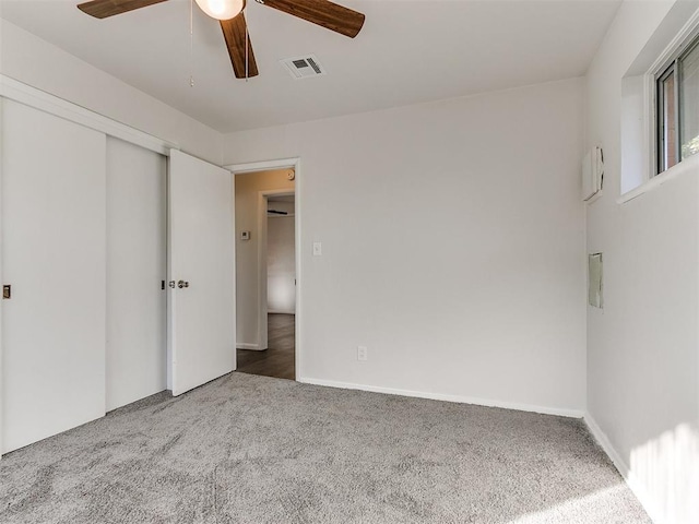 unfurnished bedroom featuring carpet, ceiling fan, and a closet