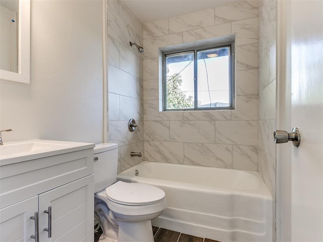 full bathroom with hardwood / wood-style floors, tiled shower / bath combo, toilet, and vanity