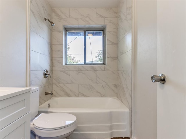 full bathroom featuring tiled shower / bath combo, toilet, and vanity