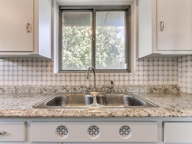 kitchen with white cabinets, decorative backsplash, and sink