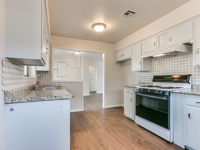 kitchen with white cabinetry, gas range gas stove, sink, light hardwood / wood-style flooring, and custom range hood