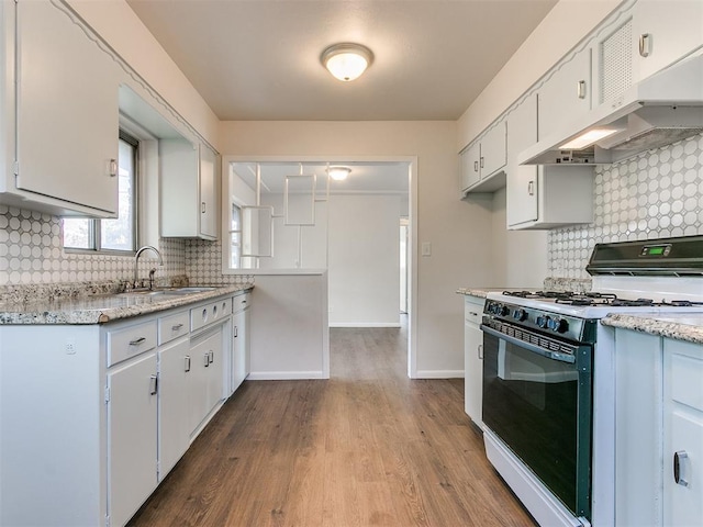 kitchen featuring backsplash, white cabinetry, white gas stove, and extractor fan