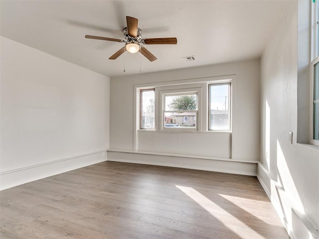 empty room with ceiling fan and light hardwood / wood-style floors