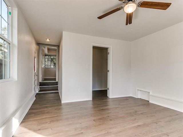 unfurnished room featuring hardwood / wood-style floors, ceiling fan, and a healthy amount of sunlight