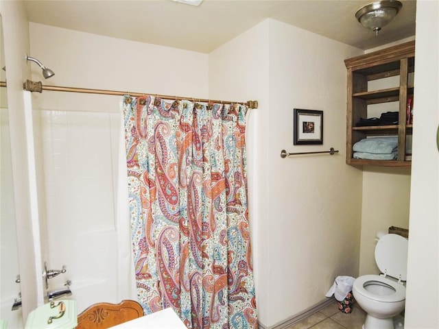 bathroom with tile patterned floors, shower / tub combo with curtain, and toilet