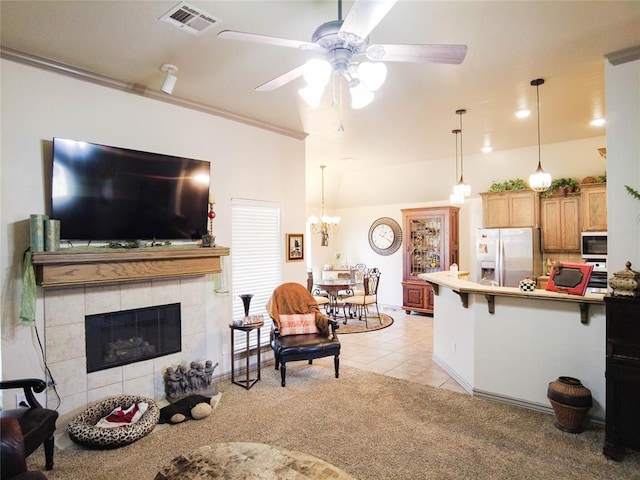 living room with a tile fireplace, light carpet, crown molding, and ceiling fan with notable chandelier