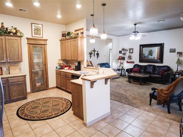 kitchen with a kitchen bar, ceiling fan, ornamental molding, light colored carpet, and kitchen peninsula