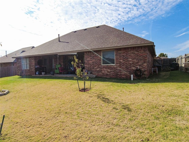 back of property featuring a lawn and a patio