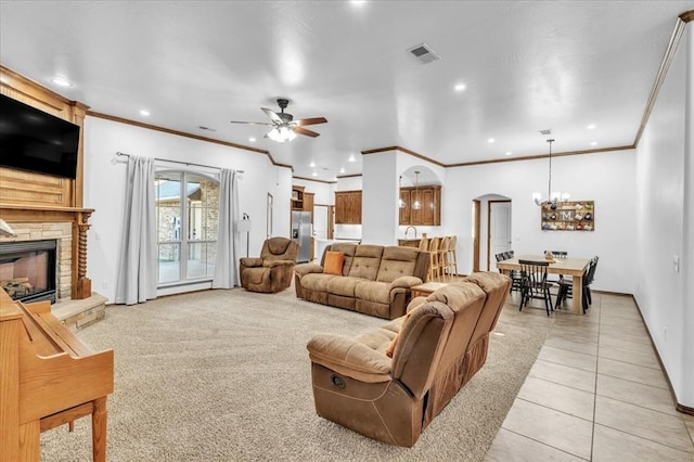 tiled living room with a fireplace, ceiling fan with notable chandelier, and ornamental molding