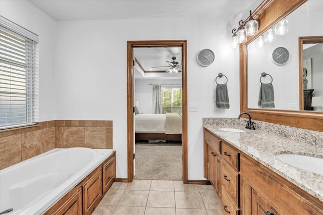 bathroom with tile patterned floors, vanity, ceiling fan, and a bathing tub