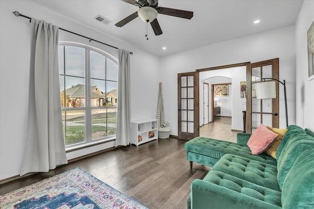 interior space with ceiling fan, wood-type flooring, french doors, and a baseboard heating unit