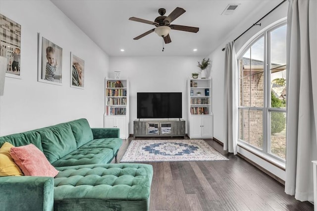 living room featuring ceiling fan and dark wood-type flooring