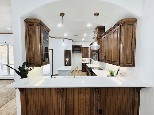 kitchen with a peninsula, tasteful backsplash, appliances with stainless steel finishes, and ornamental molding