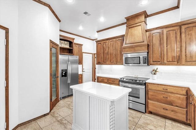 kitchen featuring tasteful backsplash, a kitchen island, appliances with stainless steel finishes, ornamental molding, and light countertops