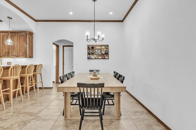 dining area with light tile patterned flooring, baseboards, arched walkways, and ornamental molding