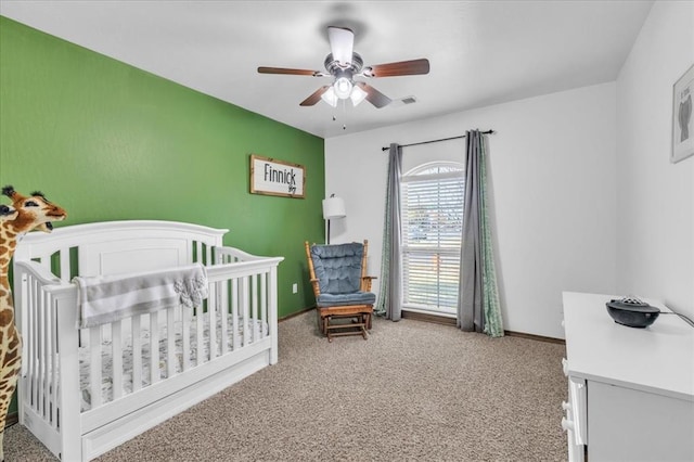 bedroom featuring baseboards, visible vents, light colored carpet, ceiling fan, and a nursery area