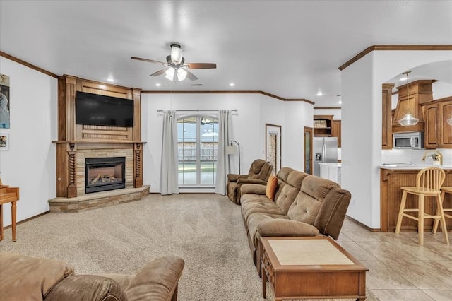 living area featuring recessed lighting, light carpet, crown molding, and a stone fireplace