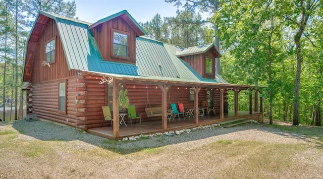 back of house with a lawn and covered porch