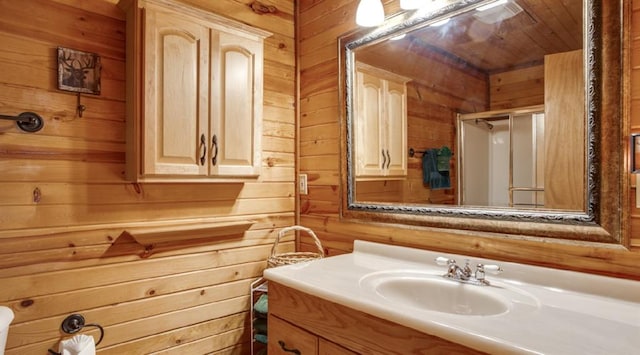 bathroom with wood ceiling, vanity, a shower with door, and wooden walls