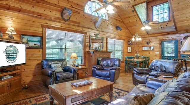 living room with wood-type flooring, high vaulted ceiling, ceiling fan, and wood walls