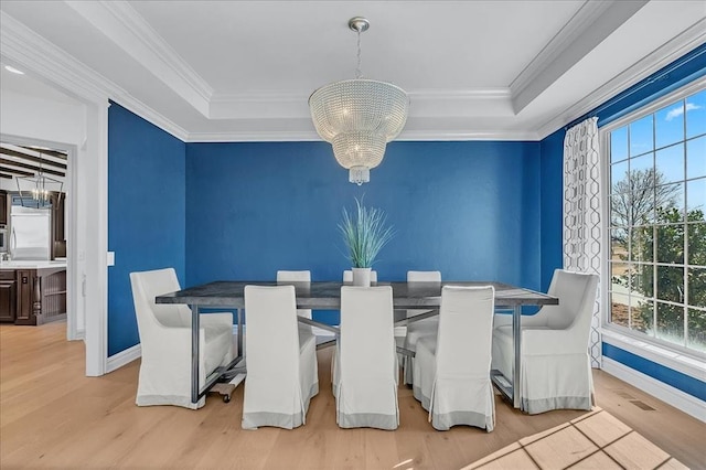 dining room featuring crown molding, plenty of natural light, a chandelier, and light hardwood / wood-style flooring