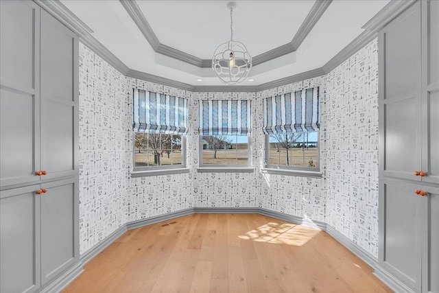 unfurnished room featuring light wood-type flooring, crown molding, and a healthy amount of sunlight