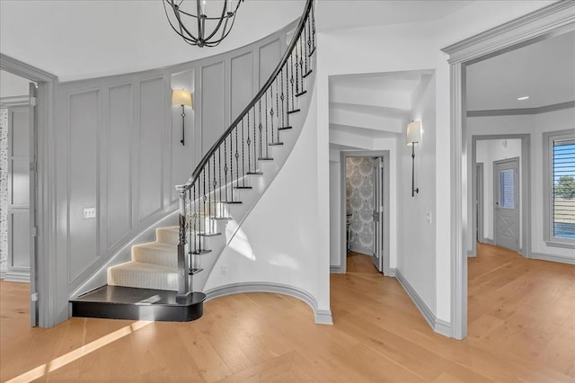 staircase with hardwood / wood-style flooring and crown molding