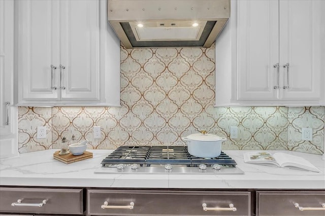 kitchen featuring light stone countertops, white cabinetry, exhaust hood, and stainless steel gas stovetop